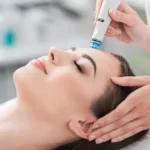 Nahaufnahme einer entspannten Frau mit geschlossenen Augen während einer HydraFacial-Behandlung in einem ruhigen Salon