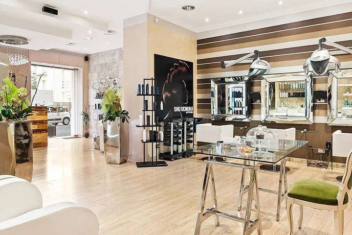 Elegante Styling-Plätze im Hair Queen in Cagliari mit cremefarben-braun gestreiften Wänden und großen silbernen Pflanzgefäßen.