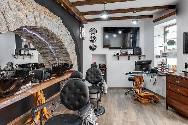 Rustikaler Barber-Stuhl vor einer steinernen Bogenwand bei La Bottega di Pablo im Bergort Lanusei.