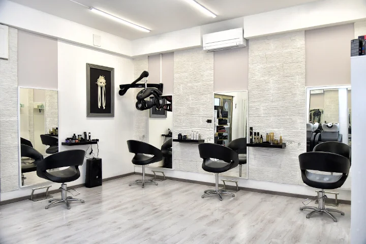 Moderne Styling-Plätze bei Sp Beauty di Serena Pinna nahe der Pittulongu-Strände in Olbia, mit schwarzen Stühlen und großen Spiegeln.