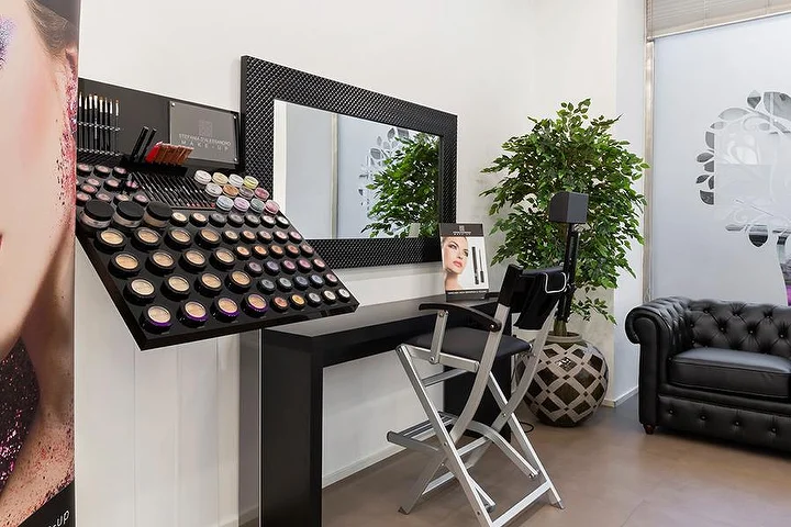 Helles Nagelstudio Top Estetica in Villanova, Cagliari, mit türkiser Akzentwand, floralen Tischen und Marmorboden.